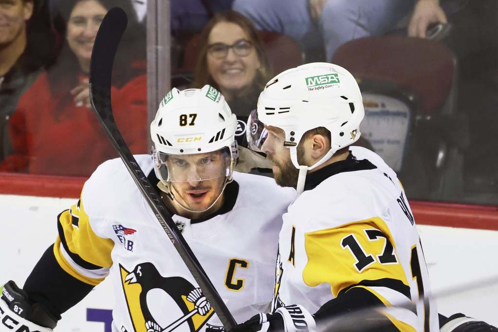 Pittsburgh Penguins' Bryan Rust, right, celebrates his goal against the Calgary Flames with Sidney Crosby during the third period of an NHL hockey game in Calgary, Alberta, Wednesday, Jan. 21, 2026. (Larry MacDougal/The Canadian Press via AP)