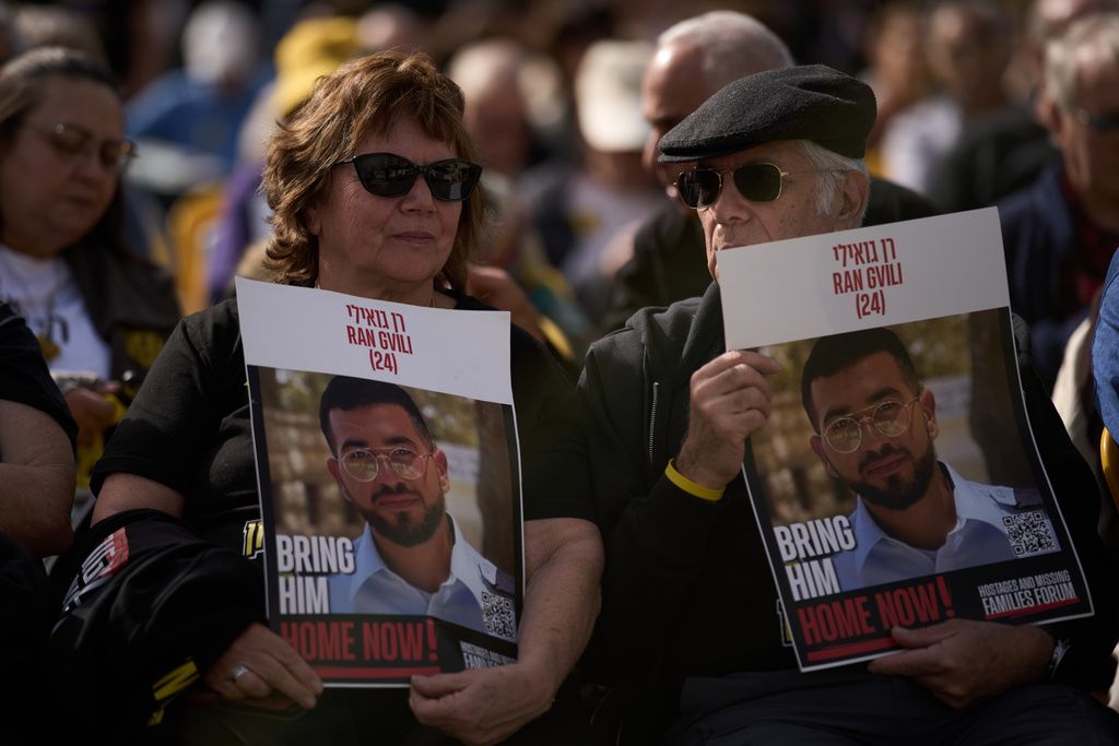 People hold signs with a photo of Ran Gvili, who was killed while fighting Hamas militants during the Oct. 7, 2023 attack and whose body has been held in Gaza ever since, during a rally calling for his return in Tel Aviv, Israel, Friday, Jan. 23, 2026. (AP Photo/Leo Correa)