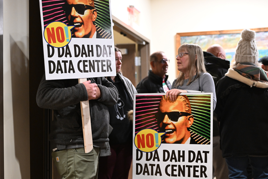 People opposed to a data center proposal at the former Pennhurst state hospital grounds talk during a break in an East Vincent Township supervisors meeting, Dec. 17, 2025, in Spring City, Pa. (AP Photo/Marc Levy)