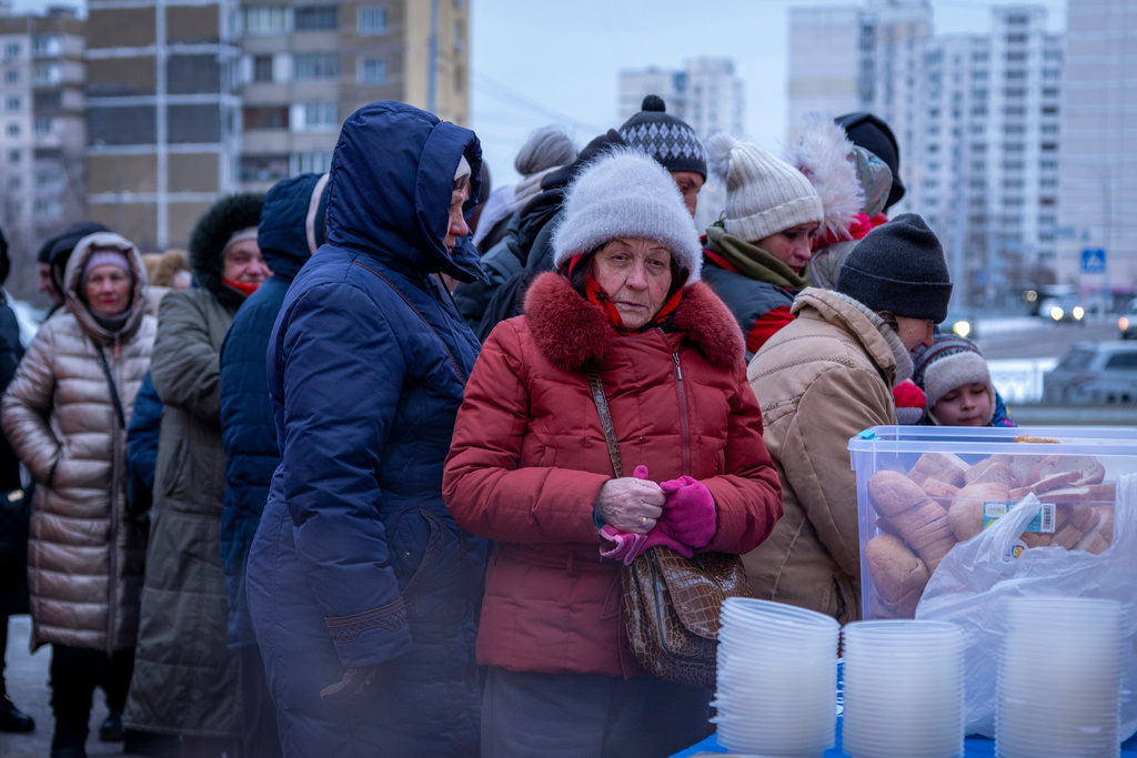 People who have no power at home following Russia's air attacks wait in line to receive free hot meals in a residential neighbourhood in Kyiv, Ukraine, Friday, Jan. 30, 2026. (AP Photo/Dan Bashakov)