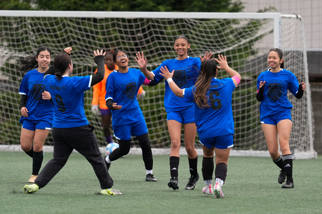 Aubrey Decraig, third from right, celebrates with teammates after scoring a goal during a soccer tournament for immigrant and refugee girls on Sunday, March 29, 2026, in Portland, Ore. (AP Photo/Jenny Kane)