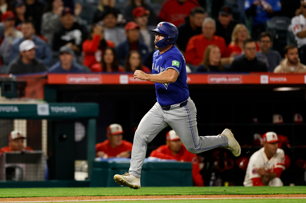 Toronto Blue Jays' Davis Schneider (36) runs to home plate to score off a single hit by Toronto Blue Jays designated hitter Eloy Jimenez (74) during the eighth inning of a baseball game against the Los Angeles Angels, Tuesday, April 21, 2026, in Anaheim, Calif. (AP Photo/Caroline Brehman)