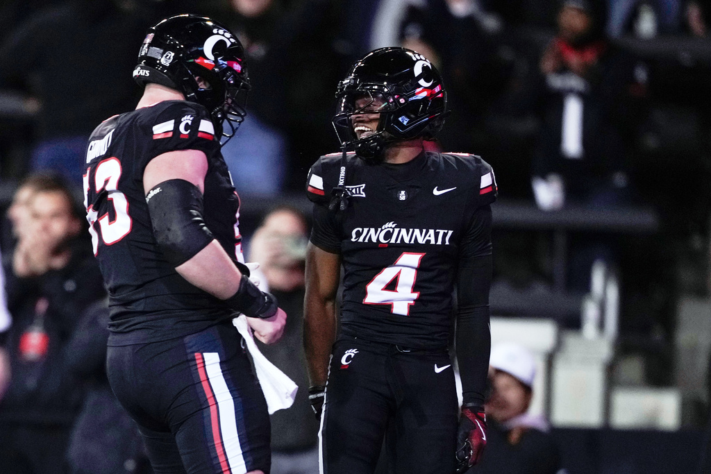 Cincinnati wide receiver Cyrus Allen (4) celebrates after scoring a touchdown with offensive lineman Gavin Gerhardt (53) during the first half of an NCAA college football game against BYU, Saturday, Nov. 22, 2025, in Cincinnati. (AP Photo/Carolyn Kaster)