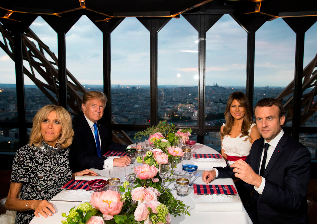FILE - In this July 13, 2017 file photo, President Donald Trump, first lady Melania Trump, French President Emmanuel Macron, right, and his wife Brigitte Macron, left, sit for dinner at the Jules Verne Restaurant at the Eiffel Tower in Paris. (AP Photo/Carolyn Kaster, File)