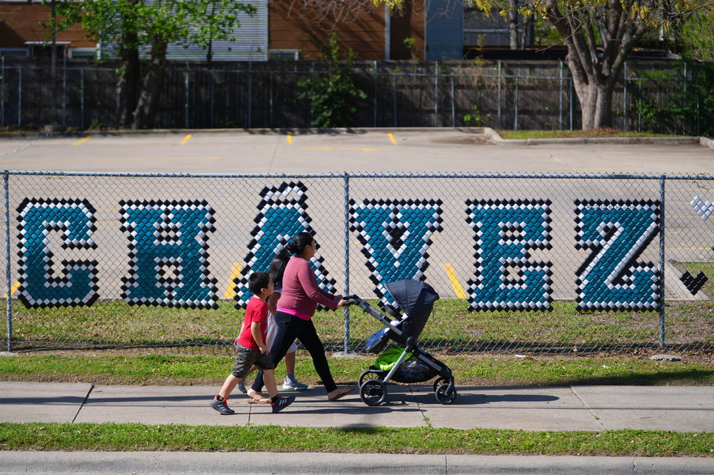 FILE - Pedestrians walk past the parking lot of the Cesar Chavez Learning Center in Dallas, March 19, 2026. (AP Photo/Julio Cortez, File)