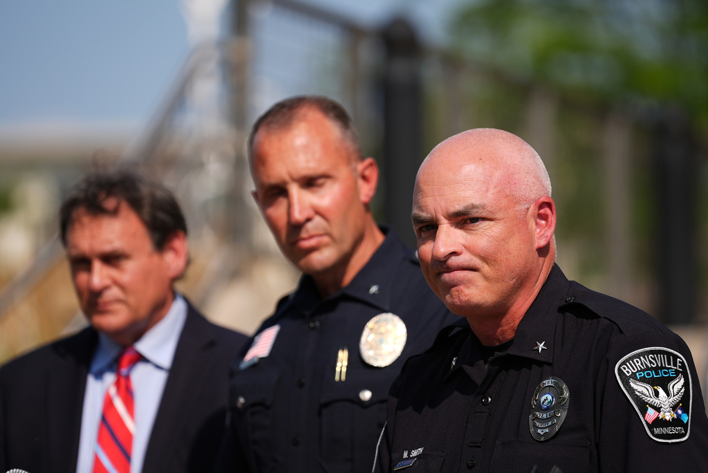 Burnsville Police Chief Matt Smith, right, attends a news conference in Hopkins, Minn., Wednesday, Aug. 12, 2026, where police said a man who killed his wife and their 7-year-old daughter at an in-home daycare is also suspected of killing a 78-year-old female relative. (AP Photo/Ellen Schmidt)
