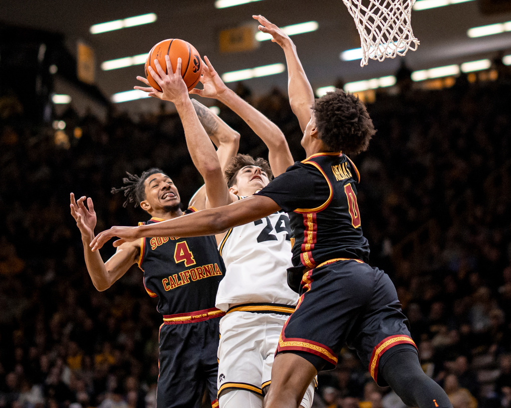 USC's Amarion Dickerson (4) and Alijah Arenas (0) defend Iowa guard Tate Sage during an NCAA college basketball game, Wednesday, Jan. 28, 2026. (Nick Rohlman/The Gazette via AP)