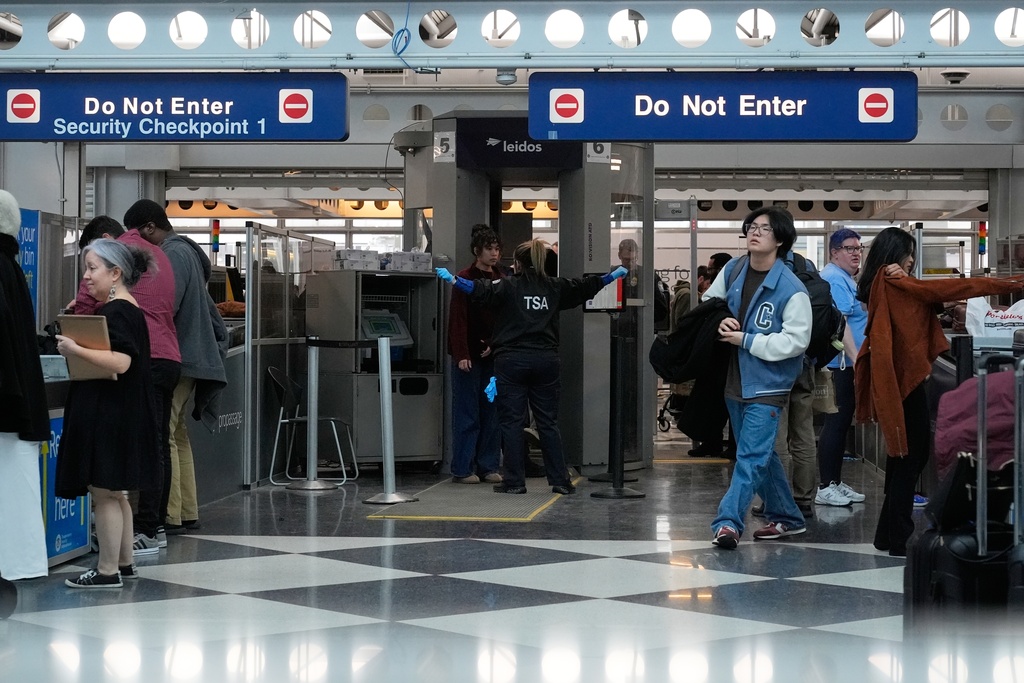 Travelers go through TSA security check at O'Hare International Airport, Saturday, March 21, 2026, in Chicago. (AP Photo/Kiichiro Sat0)