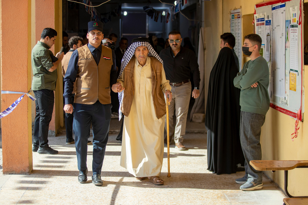Iraqi voters gather to cast their vote at a ballot station in the country's parliamentary election in Najaf, Iraq, Tuesday, Nov. 11, 2025. (AP Photo/Anmar Khalil)