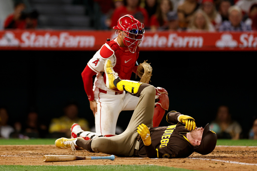 San Diego Padres' Jake Cronenworth, bottom, reacts after getting hit with a pitch during the fifth inning of a baseball game against the Los Angeles Angels, Saturday, April 18, 2026, in Anaheim, Calif. (AP Photo/Caroline Brehman)
