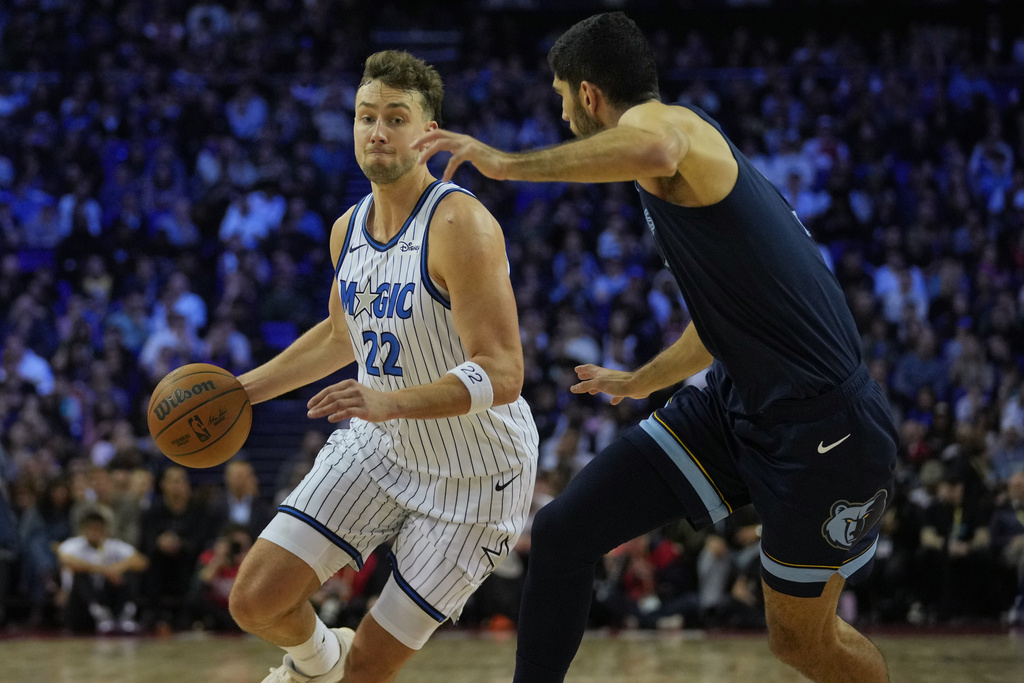 Orlando Magic forward Franz Wagner (22) drives around Memphis Grizzlies forward Santi Aldama (7) during the first half of NBA basketball game Sunday, Jan. 18, 2026, in London. (AP Photo/Kin Cheung)