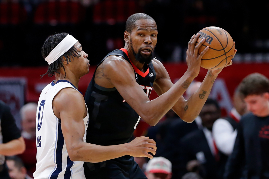 Houston Rockets forward Kevin Durant, right, looks to drive around Memphis Grizzlies forward Jaylen Wells, left, during the first half of an NBA basketball game Monday, Jan. 26, 2026, in Houston. (AP Photo/Michael Wyke)