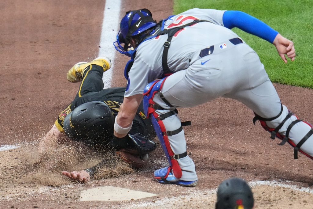 Chicago Cubs catcher Carson Kelly puts the tags out Pittsburgh Pirates' Henry Davis who was attempting to score on a sacrifice fly by Nick Gonzales during the seventh inning of a baseball game in Pittsburgh, Friday, July 24, 2026. (AP Photo/Gene J. Puskar)