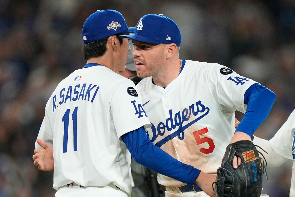 Los Angeles Dodgers relief pitcher Roki Sasaki, left, celebrates with first baseman Freddie Freeman (5) after a win over the Cincinnati Reds in Game 2 of the National League Wild Card baseball playoff series Wednesday, Oct. 1, 2025, in Los Angeles. (AP Photo/Mark J. Terrill)