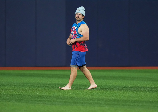 Toronto Blue Jays outfielder Davis Schneider walks barefooted in the outfield during baseball World Series workouts, Thursday, Oct. 30, 2025, in Toronto. (Nathan Denette/The Canadian Press via AP) Toronto Blue Jays outfielder Davis Schneider walks barefooted in the outfield during baseball World Series workouts, Thursday, Oct. 30, 2025, in Toronto. (Nathan Denette/The Canadian Press via AP)