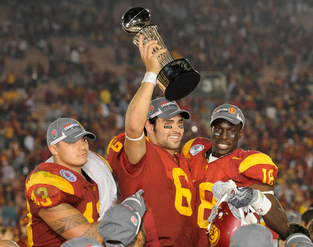 FILE - In this Jan. 1, 2009, file photo, Southern California quarterback Mark Sanchez (6) holds up the trophy as he celebrates with teammates Kaluka Maiava, left, and Damian Williams (18) after USC beat Penn State 38-24 in the Rose Bowl NCAA college football game, in Pasadena, Calif. (AP Photo/Mark J. Terrill, File)