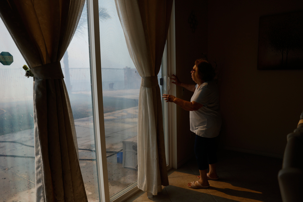 FILE - Mayra Long looks from inside her home as the Sandy Fire approaches May 19, 2026, in Simi Valley, Calif. (AP Photo/Caroline Brehman, File)