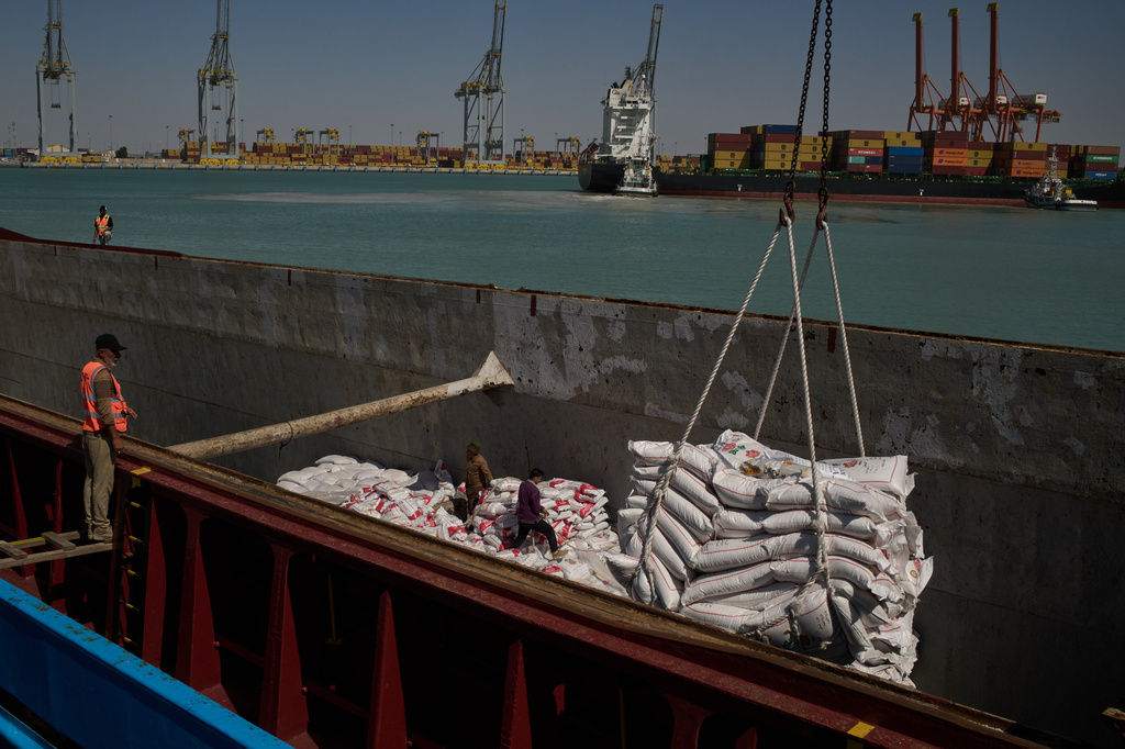 Workers offload cargo of rice from a feeder vessel into trucks at Umm Qasr Port, a deep-water port, in the city of Umm Qasr, Iraq, Friday, March 27, 2026. (AP Photo/Leo Correa)