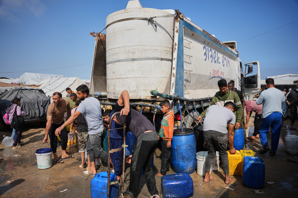 Displaced Palestinians gather to collect water from a truck at a makeshift tent camp in Khan Younis, southern Gaza Strip, Thursday, April 30, 2026. (AP Photo/Abdel Kareem Hana)
