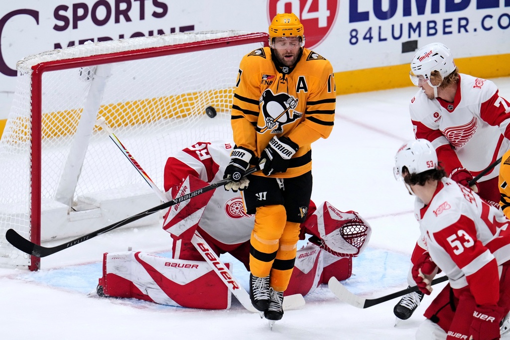 Pittsburgh Penguins' Bryan Rust (17) screens Detroit Red Wings goaltender Cam Talbot as a shot by Sidney Crosby gets past him for a goal during the first period of an NHL hockey game in Pittsburgh, Thursday, Jan. 1, 2026. (AP Photo/Gene J. Puskar)