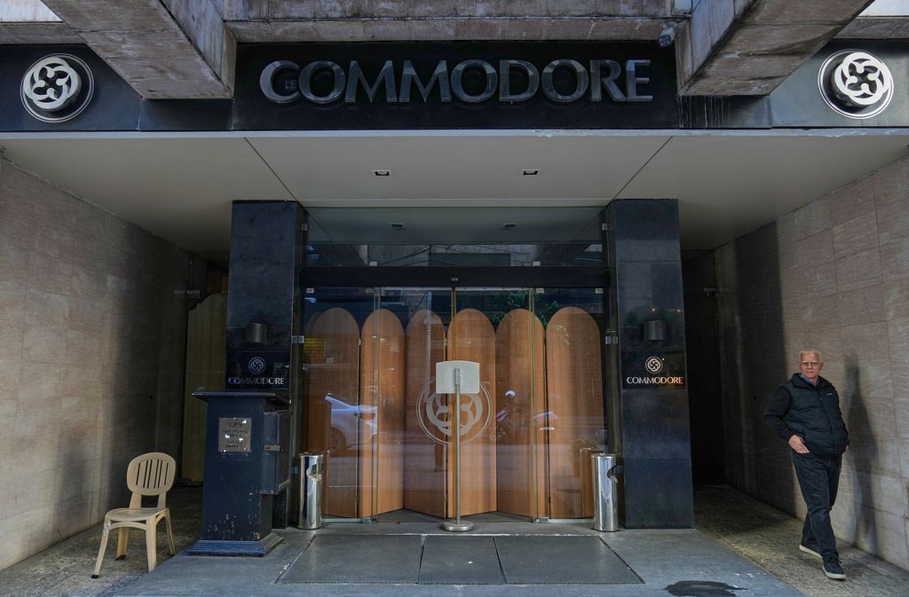 A man stands in the closed main entrance of the Commodore hotel, in Beirut, Lebanon, Sunday, Jan. 11, 2026. (AP Photo/Hussein Malla)