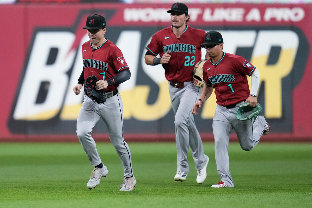 Arizona Diamondbacks outfielders Corbin Carroll (7), Max Kepler (22) and Jorge Barrosa (1) run in from the outfield after the Diamondbacks defeated the Guardians in a baseball game in Cleveland, Friday, July 31, 2026. (AP Photo/Sue Ogrocki)