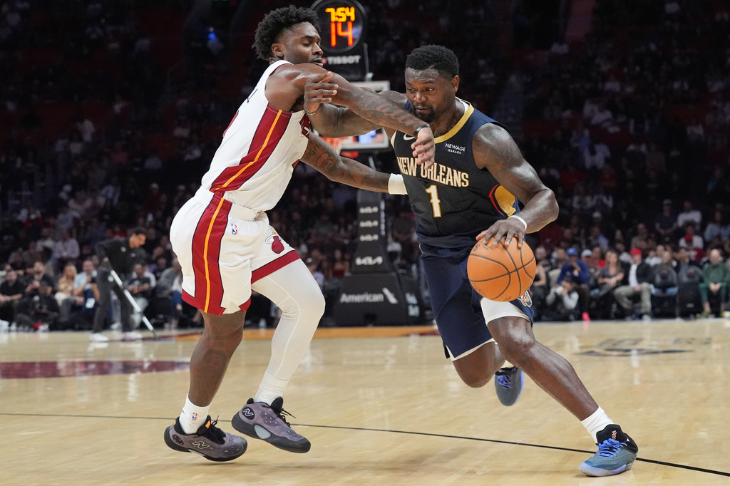 Miami Heat guard Davion Mitchell defends New Orleans Pelicans forward Zion Williamson (1) during the first half of an NBA preseason basketball game Thursday, Oct. 8, 2026, in Miami. (AP Photo/Marta Lavandier)
