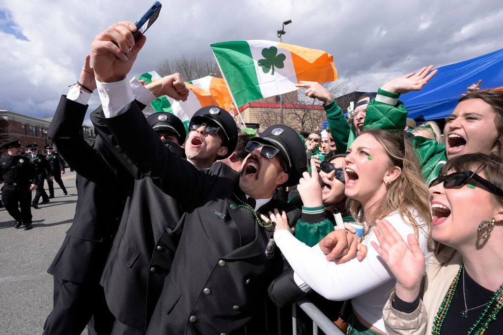 FILE - A group of firemen from around the United States pose for a selfie with spectators while marching in the St. Patrick's Day parade, March 17, 2024, in Boston's South Boston neighborhood. (AP Photo/Steven Senne, File)