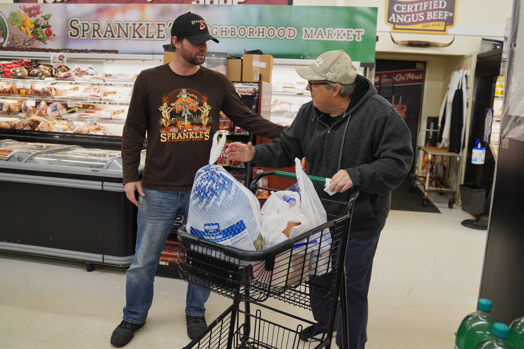 Ryan Sprankle, left, owner of Sprankle's Neighborhood Market, speaks with Timothy A. Mohney at the market Monday, Nov. 10, 2025, in Kittanning, Pa. (AP Photo/Jessie Wardarski)