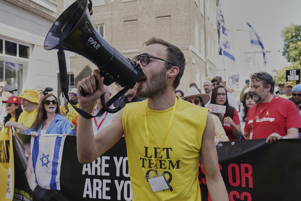 Demonstrators hold placards take part in the March for Hostages to Downing Street, in London, Sunday, Aug. 10, 2025. (AP Photo/Alberto Pezzali)