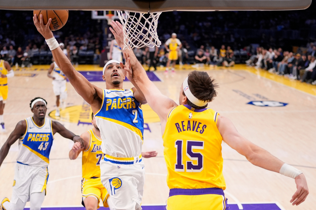 Indiana Pacers guard Andrew Nembhard (2) shoots as Los Angeles Lakers guard Austin Reaves (15) defends during the third period of an NHL hockey game Friday, March 6, 2026, in Los Angeles. (AP Photo/Mark J. Terrill)