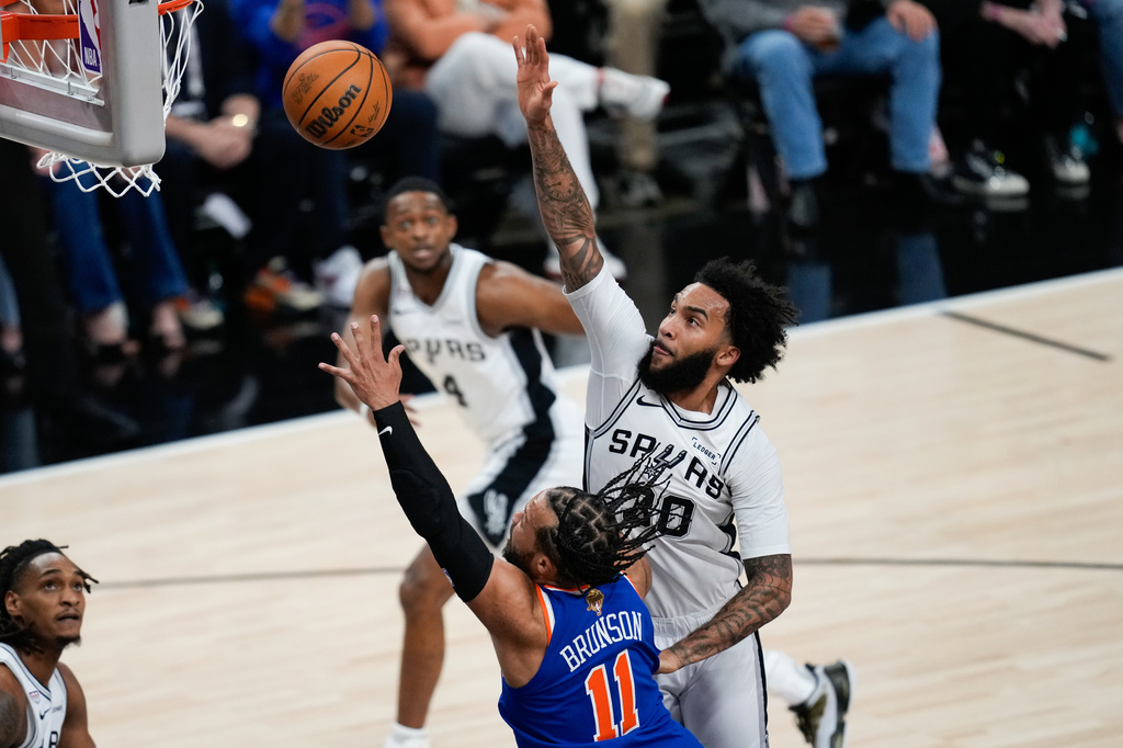 San Antonio Spurs forward Julian Champagnie (30) shoots over New York Knicks guard Jalen Brunson (11) during the first half of Game 2 of the NBA Finals basketball series, Friday, June 5, 2026, in San Antonio. (AP Photo/David J. Phillip)