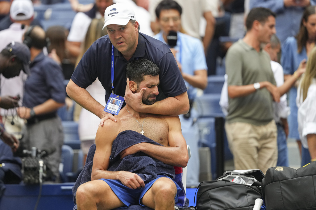 Athletic trainer Clay Sniteman works on Novak Djokovic, of Serbia, between sets against Carlos Alcaraz, of Spain, during the men's singles semifinals of the U.S. Open tennis championships, Friday, Sept. 5, 2025, in New York. (AP Photo/Kirsty Wigglesworth)