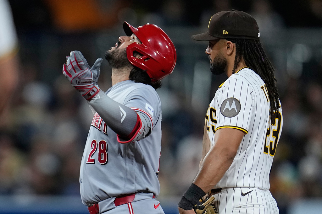 Cincinnati Reds' Eugenio Suárez (28) celebrates after hitting an RBI double as San Diego Padres second baseman Fernando Tatis Jr. looks on during the tenth inning of a baseball game Tuesday, June 9, 2026, in San Diego. (AP Photo/Gregory Bull)