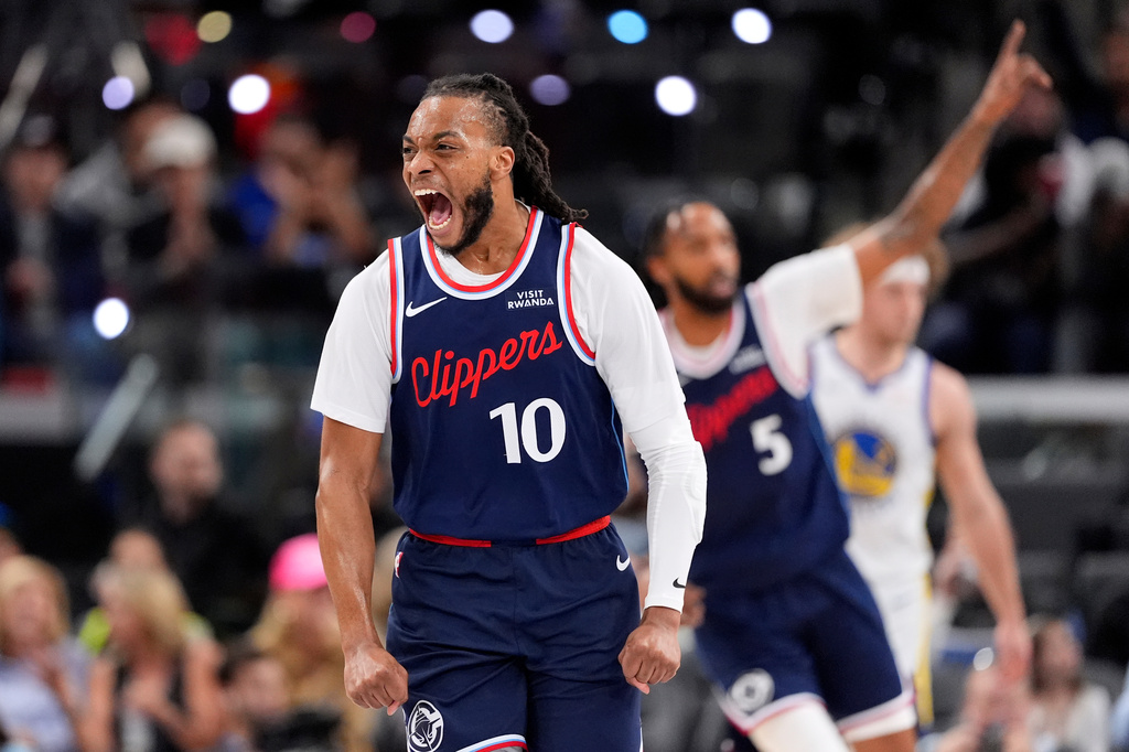 LA Clippers guard Darius Garland, left, celebrates after scoring during the first half of an NBA play-in tournament basketball game against the Golden State Warriors, Wednesday, April 15, 2026, in Inglewood, Calif. (AP Photo/Mark J. Terrill)
