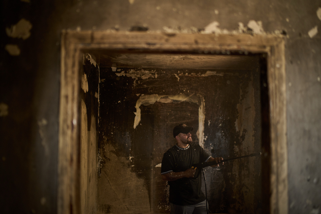 A Palestinian man cleans a room of a house damaged following an attack by Israeli settlers the previous day in the village of Sarra, near the West Bank city of Nablus, Saturday, July 25, 2026. (AP Photo/Leo Correa)