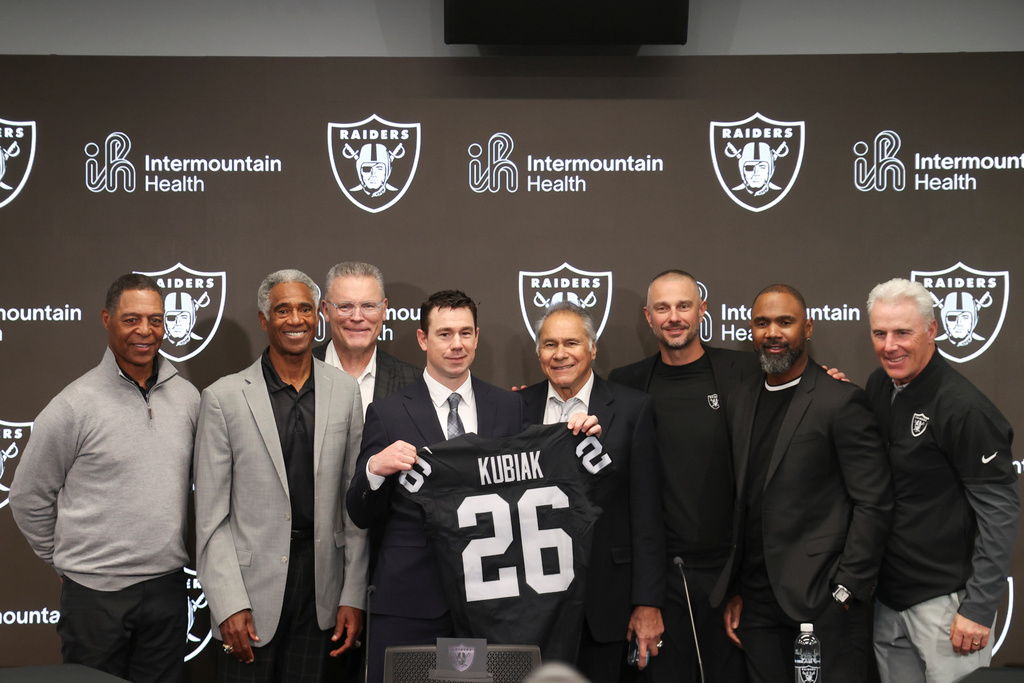 Las Vegas Raiders new head coach Klint Kubiak, fourth from left, poses with from left, Marcus Allen, Mike Haynes, Howie Long, Jim Plunkett, general manager John Spytek and Charles Woodson during an introductory news conference at the NFL football team's training facility Tuesday, Feb. 10, 2026, in Henderson, Nev. (AP Photo/Ian Maule)