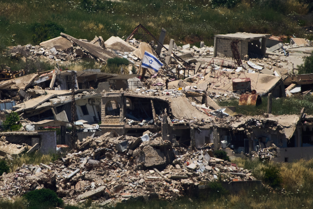 An Israeli flag hangs on a destroyed building in southern Lebanon as seen from northern Israel, Thursday June 4, 2026. (AP Photo/Ariel Schalit)