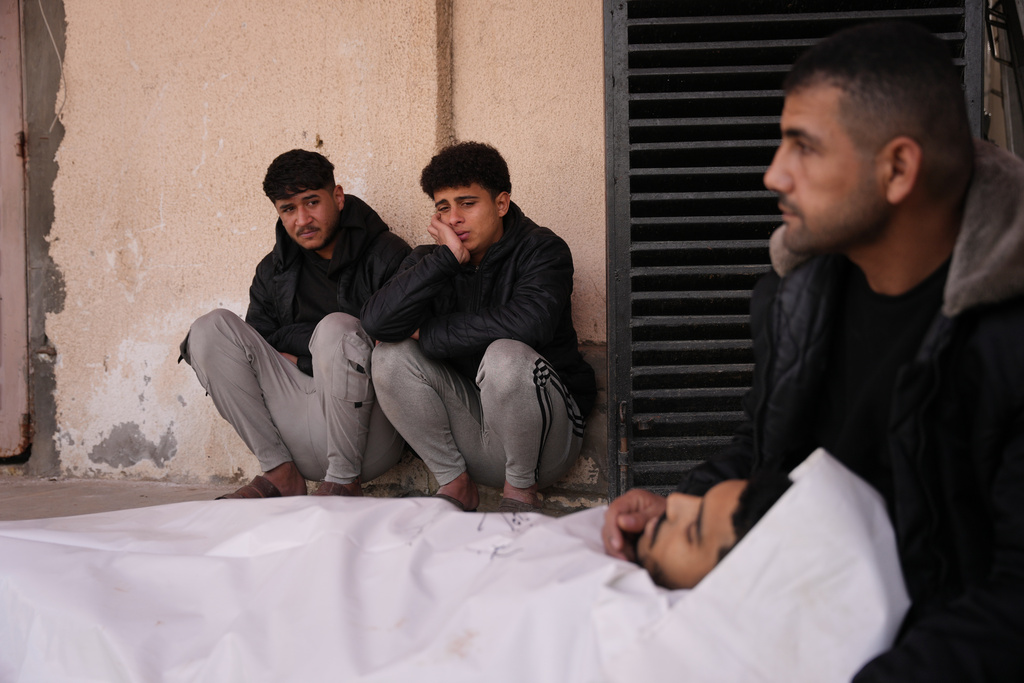 Palestinians mourn over the body of Waleed Darweesh, 20, who was killed in an Israeli strike, during his funeral at Al-Aqsa Hospital in Deir al-Balah, central Gaza Strip, Friday, Jan. 30, 2026. (AP Photo/Abdel Kareem Hana)