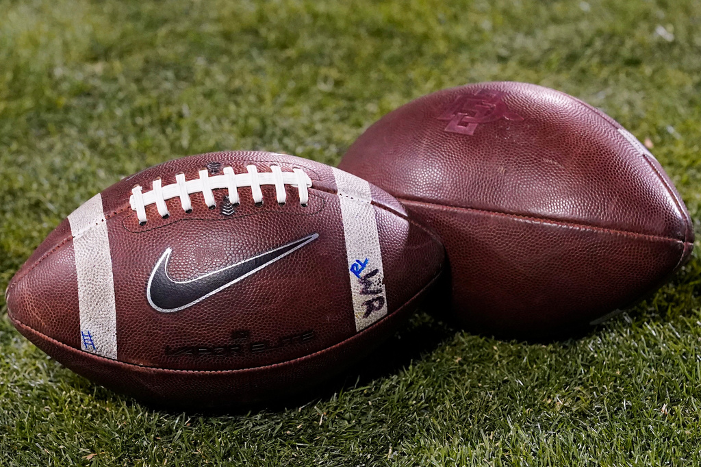 FILE - Footballs rest on the field in the second half of an NCAA college football game Nov. 28, 2020, in Boulder, Colo. (AP Photo/David Zalubowski, File)