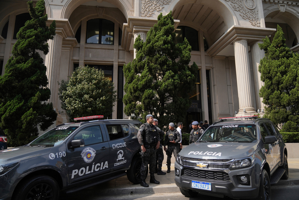 Police stand guard in front of a building during an operation investigating investment funds and the fuel sector, on Avenida Faria Lima, in Sao Paulo, Thursday, Aug. 28, 2025. (AP Photo/Andre Penner)