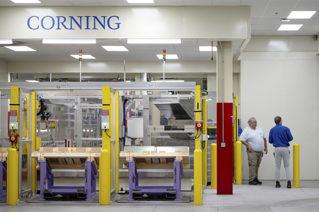 Stacks of glass are seen while employees stand nearby during a tour of Corning's iPhone glass manufacturing facility Friday, Sept. 12, 2025, in Harrodsburg, Ky. (AP Photo/Jon Cherry)