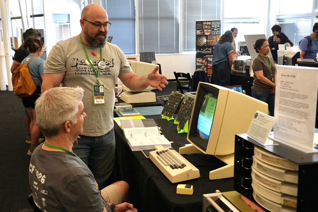 Software engineer Josh Dersch, standing, shows a 1970s Xerox Alto computer he restored at the Vintage Computer Festival in Mountain View, Calif., Sunday, Aug. 2, 2026. (AP Photo/Terry Chea)