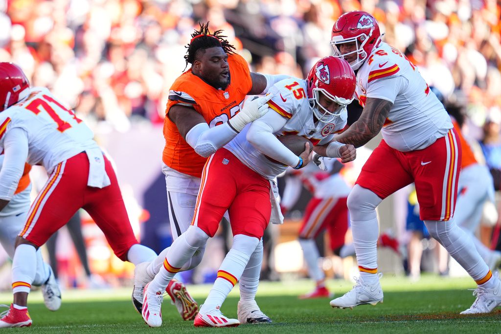 Denver Broncos defensive tackle Malcolm Roach loses his helmet while pursuing Kansas City Chiefs quarterback Patrick Mahomes (15) during the first half an NFL football game Sunday, Nov. 16, 2025, in Denver. (AP Photo/Jack Dempsey)