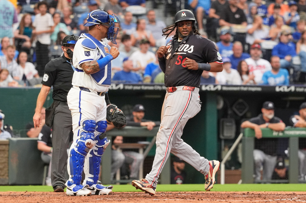 Minnesota Twins' Josh Bell (56) scores on a double-play hit into by Victor Caratini during the fourth inning of a baseball game against the Kansas City Royals, Wednesday, Aug. 5, 2026, in Kansas City, Mo. (AP Photo/Charlie Riedel)