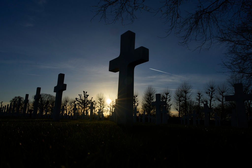 The sun sets over the graves of more than 8.300 WWII soldiers at the Netherlands American Cemetery in Margraten, Netherlands, Thursday, Dec. 11, 2025, where the American Battle Monuments Commission removed two displays honoring Black liberators from the visitors center. (AP Photo/Peter Dejong)