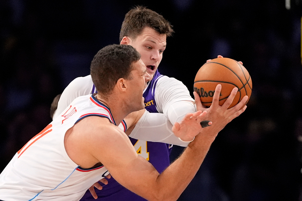 LA Clippers center Brook Lopez, left, tries to shoot as Los Angeles Lakers center Walker Kessler defends during the first half of an NBA basketball game Friday, Oct. 23, 2026, in Los Angeles. (AP Photo/Mark J. Terrill)