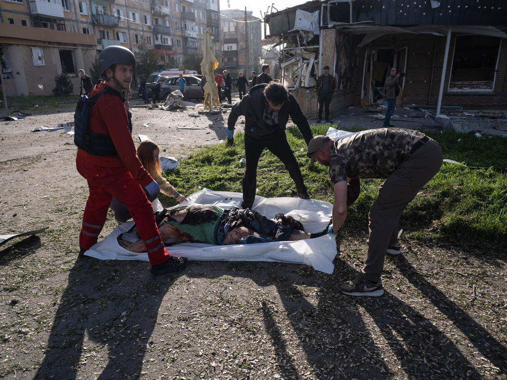 EDS NOTE: GRAPHIC CONTENT - In this photo provided by Ukraine's 93rd Kholodnyi Yar Separate Mechanized Brigade press service, people cover bodies of civilians killed in Russia's aerial guided bomb attack in Kramatorsk, Donetsk region, Ukraine, Tuesday, May 5, 2026. (Iryna Rybakova/Ukraine's 93rd Mechanized Brigade via AP)