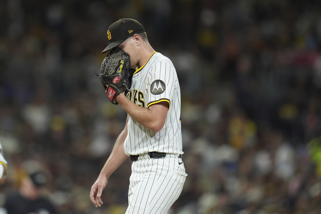 San Diego Padres starting pitcher Nick Pivetta puts his face in his glove as he walks back onto the mound during the fourth inning of a baseball game against the Milwaukee Brewers Monday, Sept. 22, 2025, in San Diego. (AP Photo/Gregory Bull)