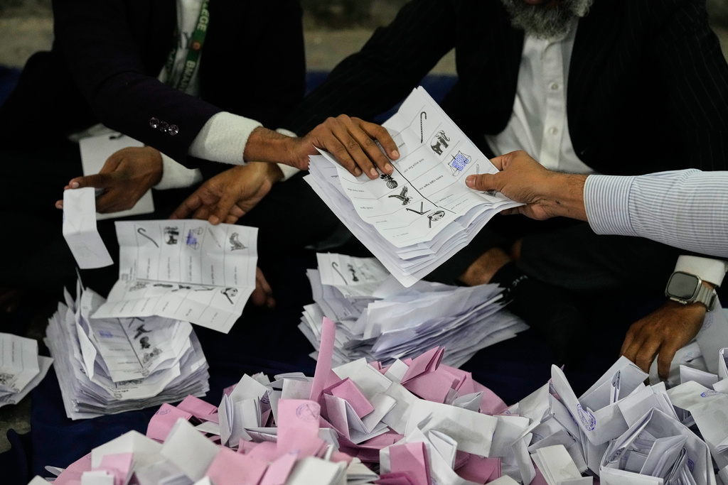 A Bangladeshi polling official handing over ballots shortly after the voting of national parliamentary election ended at a polling station in Dhaka, Bangladesh, Thursday, Feb. 12, 2026. (AP Photo/Anupam Nath)